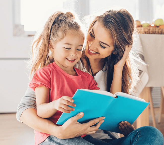 A woman and girl reading a book together.